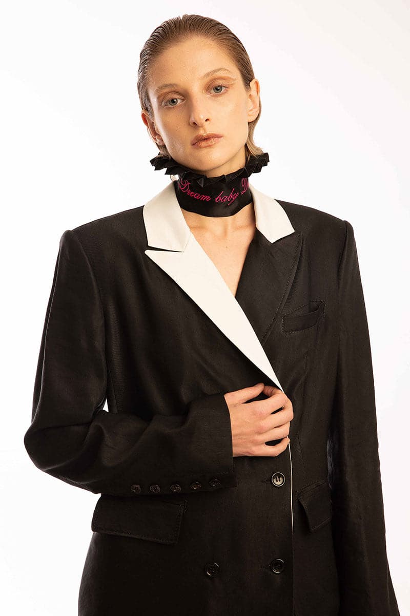 Vaska black double-breasted coat with a white collar, stylish and tailored for a sophisticated look.