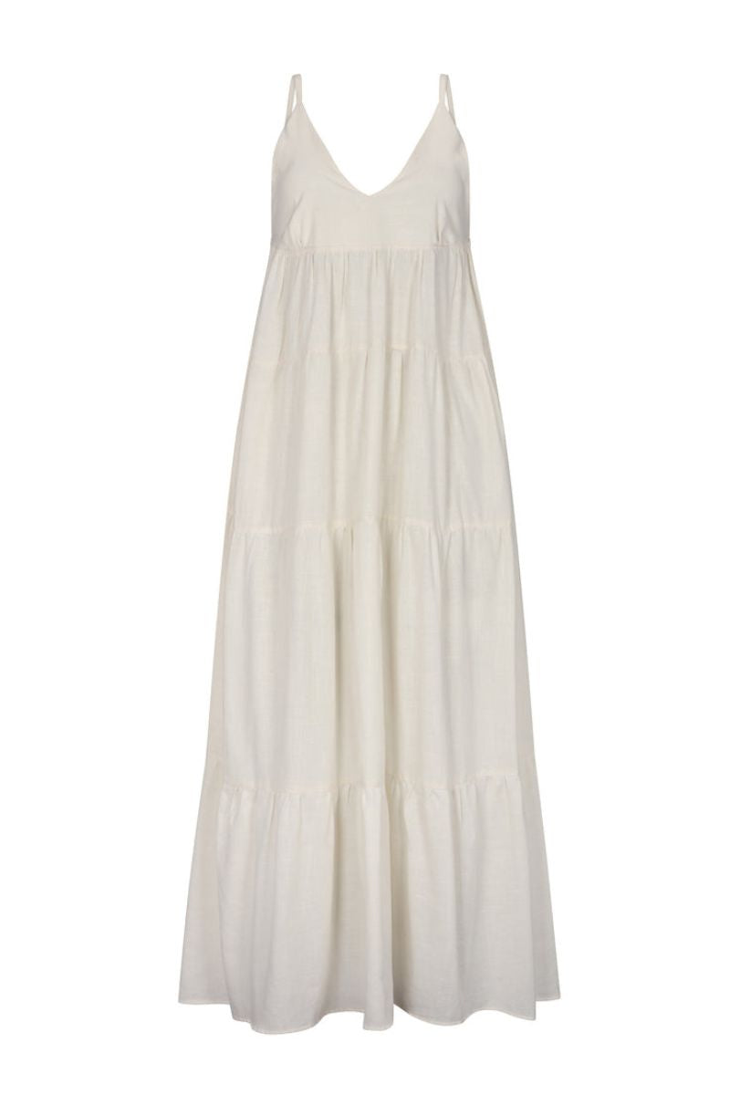 Nelblu Tiemos ecru maxi dress shown on a hanger with flowing fabric and sleeveless design.