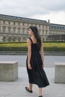 Black Luna midi dress by Summer Away displayed on a hanger, showcasing its elegant midi length and stylish design.