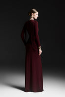 Red Corvina draped floor-length gown by Maison Des Copains, featuring elegant fabric and flowing silhouette.
