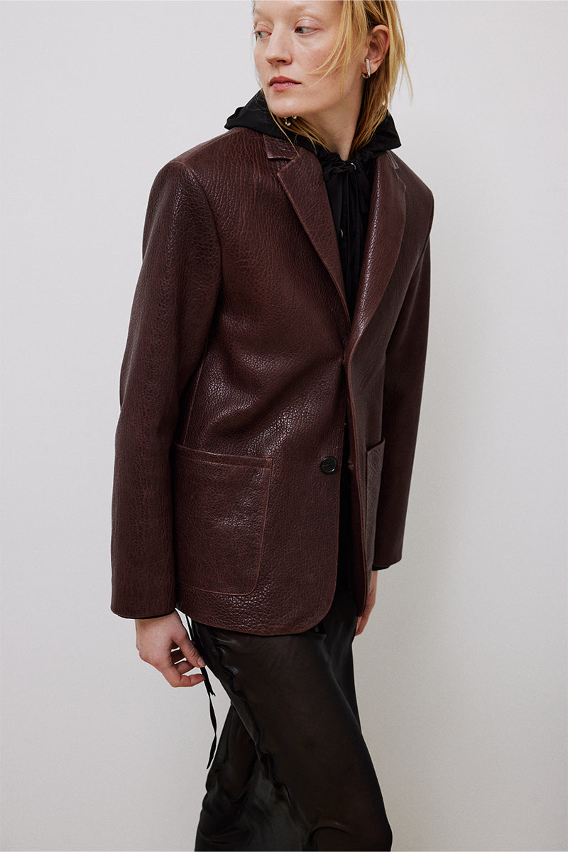 Brown leather mid-oversized jacket by TAGG, featuring a relaxed fit, classic collar, and stylish design for casual wear.