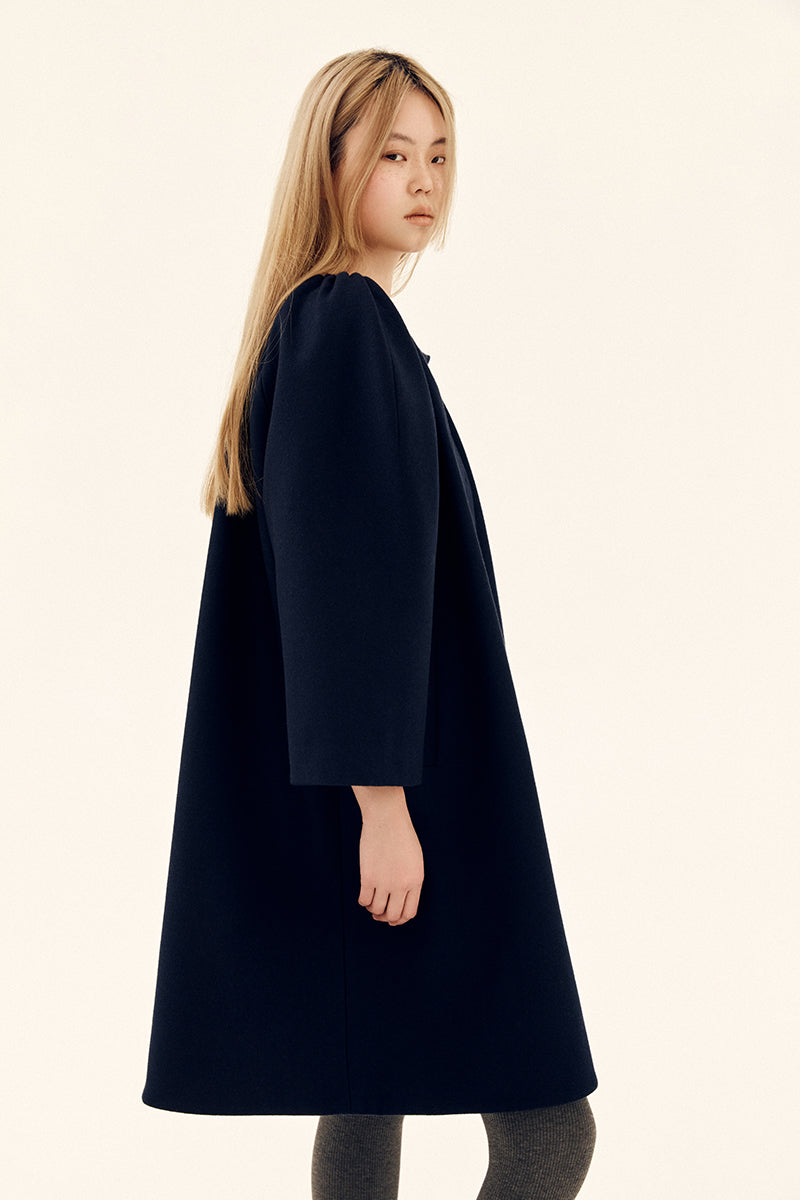Chictopia navy midnight cocoon coat hanging on a hanger, showcasing its oversized, cozy design and smooth fabric.