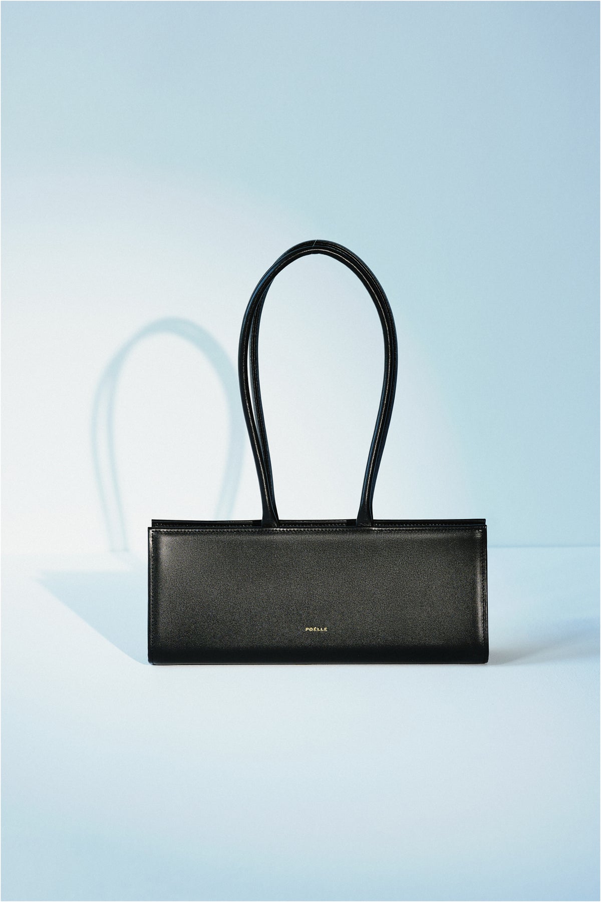 Poelle Cecilie Black top handle bag with sleek design, featuring sturdy handles and a structured silhouette.