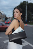 Black POELLE CECILIE top handle bag with sturdy handles and sleek design, perfect for stylish everyday use.