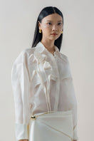 White sheer organza shirt by DOC BAN, featuring lightweight, transparent fabric and classic shirt design with collar and button front.