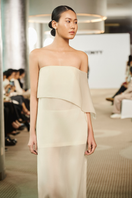 Tan vanilla drape maxi dress by TONYY featuring flowing fabric and elegant silhouette, perfect for summer or special occasions.