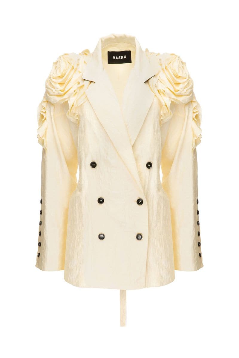 Beige oversized jacket by Vaska featuring a floral rose pattern, displayed on a hanger showing the relaxed fit and design details.