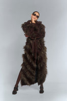 Brown faux fur maxi coat with diagonal panel design by Fortini, featuring a plush, textured appearance and full-length silhouette.