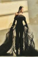 L'SCARLETT form-fitting off-shoulder long-sleeve poly crepe jumpsuit displayed on a hanger with a neutral background.