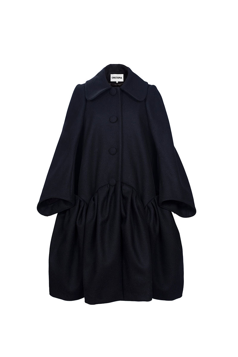 Chictopia DORA wool coat in beige with classic lapel collar, front buttons, and tailored fit, displayed hanging on a wooden hanger.