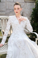 Elegant floral long sleeve lace gown by Tracy Studio featuring intricate lace details and a flowing silhouette.
