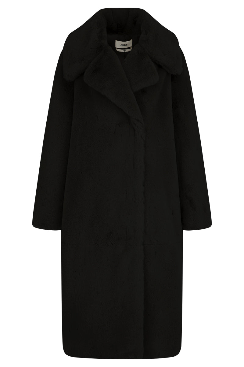 Black oversized shearling coat by JINSUN, showing the plush textured collar and relaxed fit on a model.