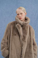 Brown oversized shearling coat by JINSUN, featuring a cozy, plush shearling exterior and relaxed fit for stylish warmth.