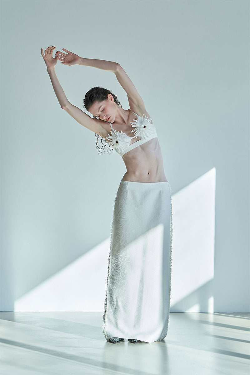 JINSUN PAPPUS Tweed Maxi Skirt in ivory, flowing design with textured fabric, displayed on a neutral background.