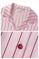 Pink striped silk pajama set by Not Just Pajama featuring a long-sleeve top and matching pants from the Museum of Crush collection.