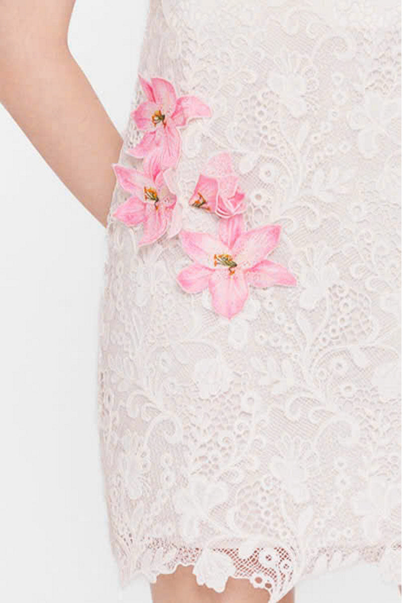Valenciani white strapless mini lace dress featured on a model, showcasing its fitted bodice and delicate lace details.