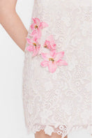 Valenciani white strapless mini lace dress featured on a model, showcasing its fitted bodice and delicate lace details.