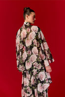 Nur Karaata Beatrice Maxi Dress displayed on a hanger with flowing fabric and a stylish silhouette.