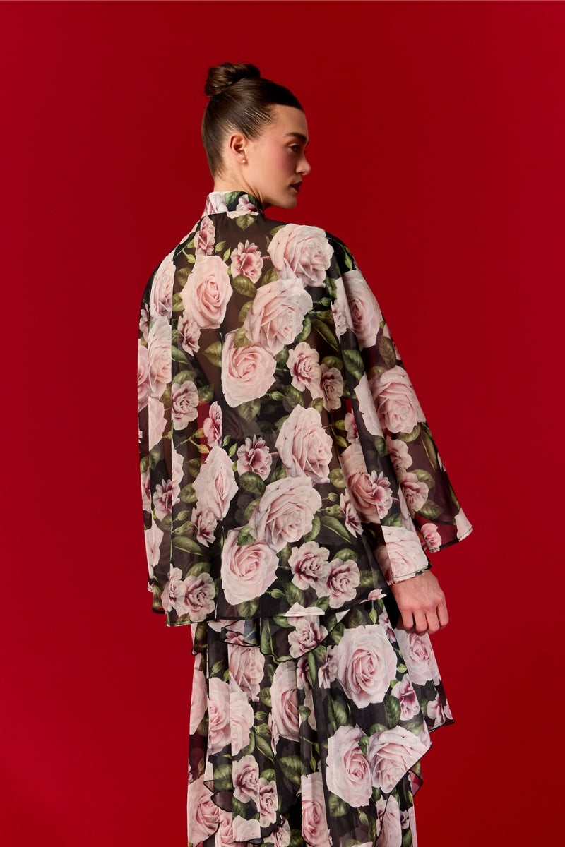 Nur Karaata Beatrice Maxi Dress displayed on a hanger with flowing fabric and a stylish silhouette.