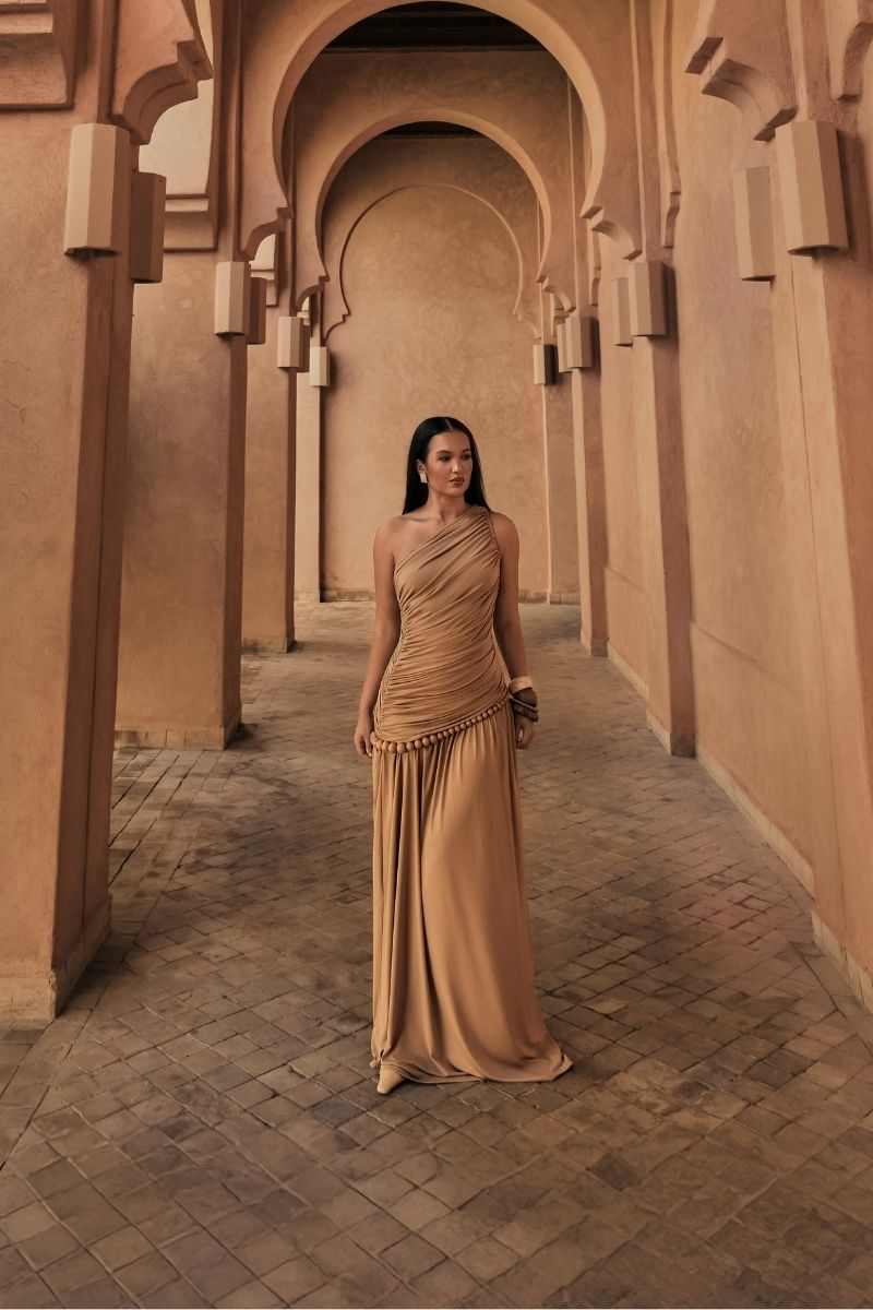Khanum's tan KASBA maxi dress displayed on a hanger, featuring a flowing fabric and elegant design perfect for stylish occasions.