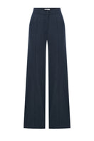 Nazlı Ceren Millie linen trousers in dark navy, showing a relaxed fit with a waistband and side pockets on a model.