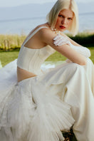 White crepe pants with ruffled train by Sudi Etuz, featuring a stylish, flowy design and ruffle details on the train.