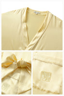 Soft butter yellow silk robe from Not Just Pajama's Timeless Collection, shown hanging with smooth fabric and elegant design.