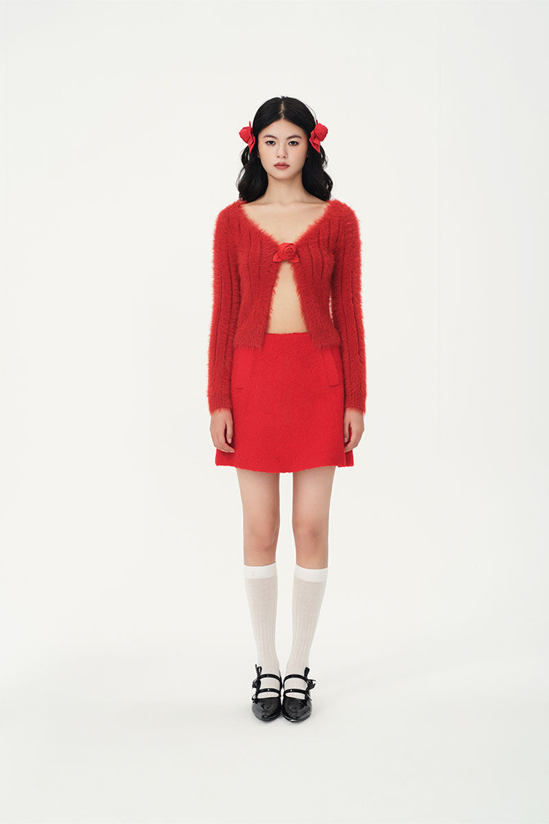 Brick red Chictopia rose cardigan displayed on a hanger, showcasing its soft knit fabric and classic button-up design.