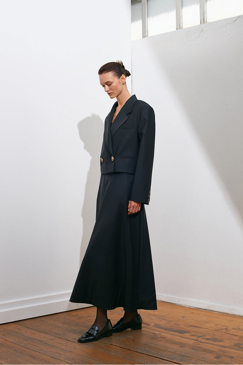 Black GURU crop blazer by Acaria Studio, tailored fit with structured lapels, worn open over a shirt.