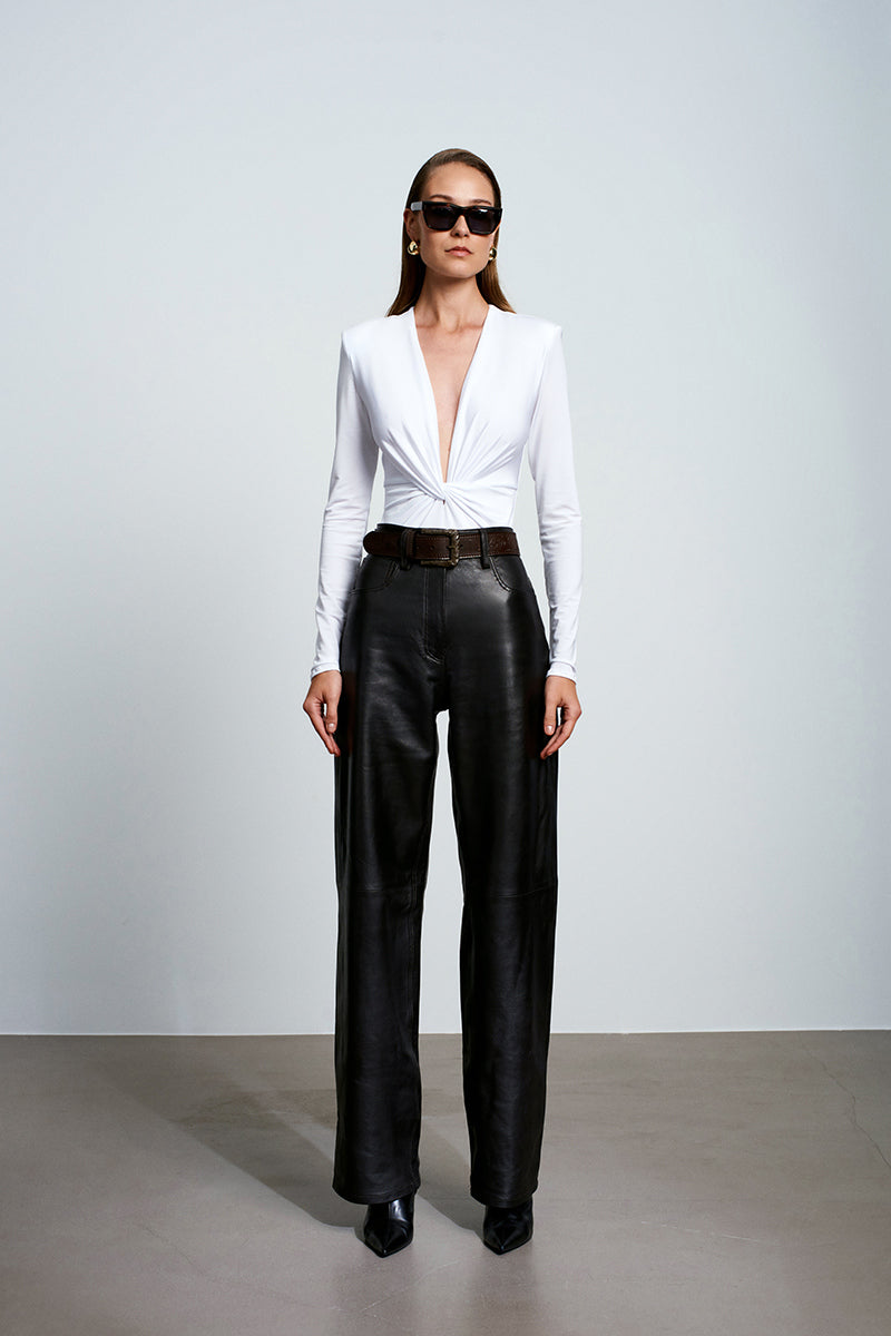 White Chandra bodysuit by Acaria Studio, a fitted tops piece with sleek design and smooth fabric, shown on a model.