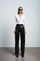 White Chandra bodysuit by Acaria Studio, a fitted tops piece with sleek design and smooth fabric, shown on a model.