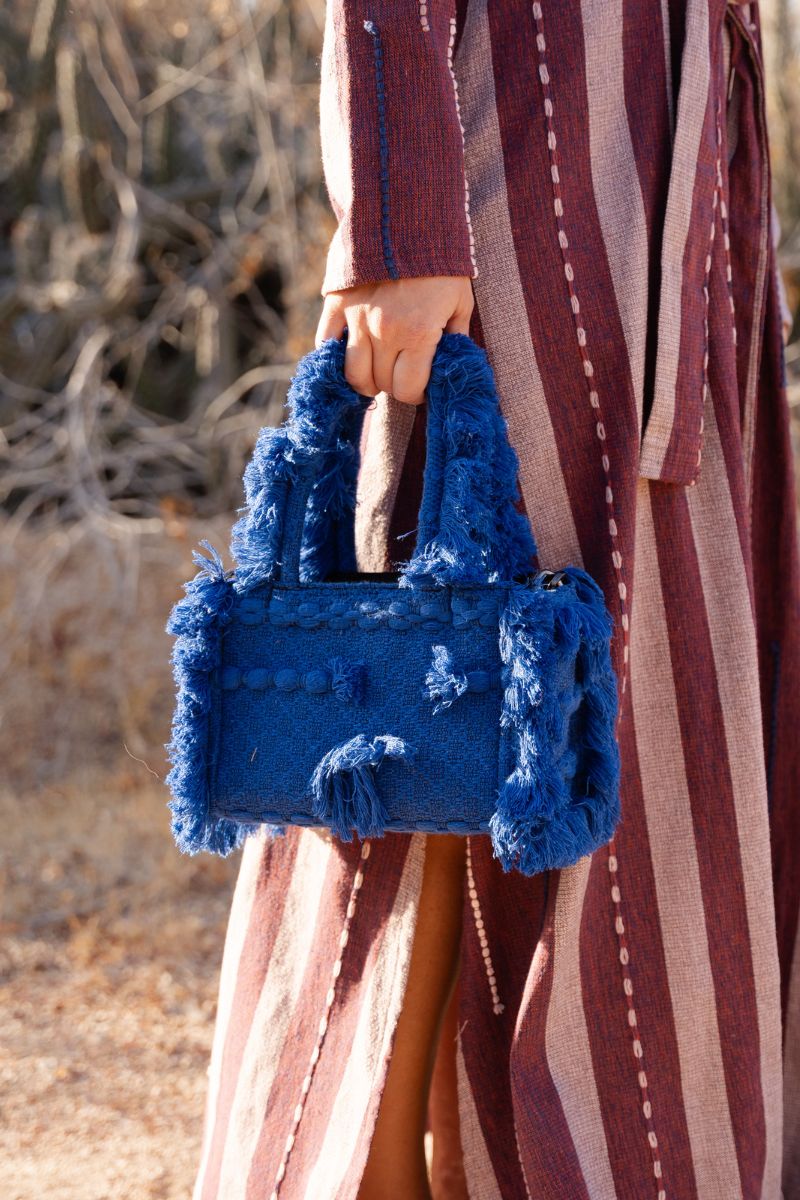 Navy blue Bani MINI POKA top handle bag with a sleek design and structured handle, perfect for casual or formal wear.