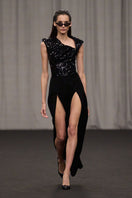 Lili Blanc asymmetric sleeveless jumpsuit with a stylish design, featuring a fitted waist and elegant drape, on a model.