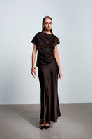 Brown satin maxi skirt by Acaria Studio with a flowing silhouette and elegant design, styled with a smooth waistband.