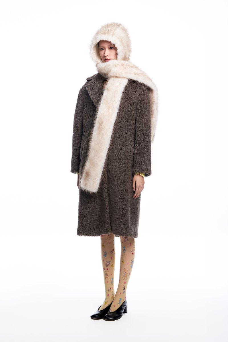 Chictopia faux fur hood scarf draped around a woman's neck, showcasing soft, plush faux fur with hood detail for warmth and style.