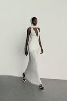 Khanum's Kaylin white gown featuring elegant fabric and a flowing design, displayed on a dress form.