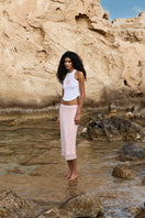 Light pink IKINITA Sunrise Top with ruffled neckline and short sleeves, displayed on a hanger.
