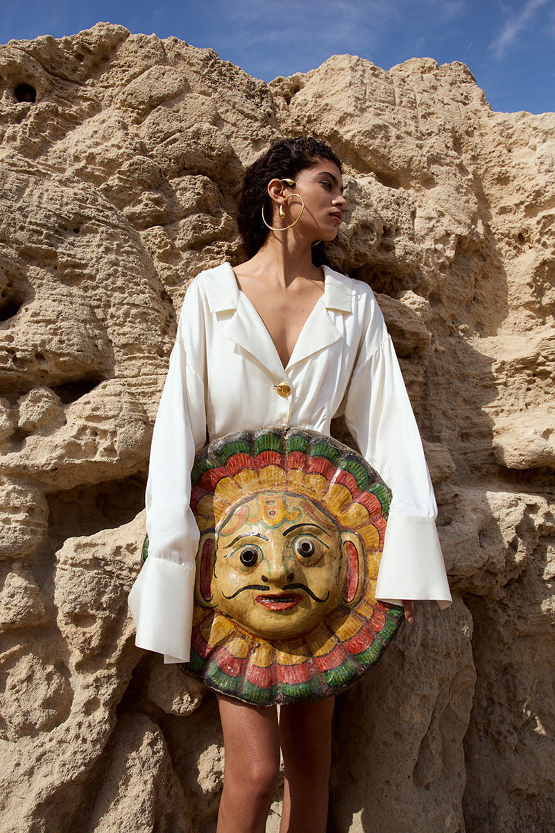 Cream mini shirt dress by IKINITA featuring a classic collar, button front, and short sleeves, displayed on a hanger.