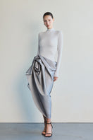 Elegant white turtleneck gown by Le Thanh Hoa featuring a sleek silhouette and sophisticated design.
