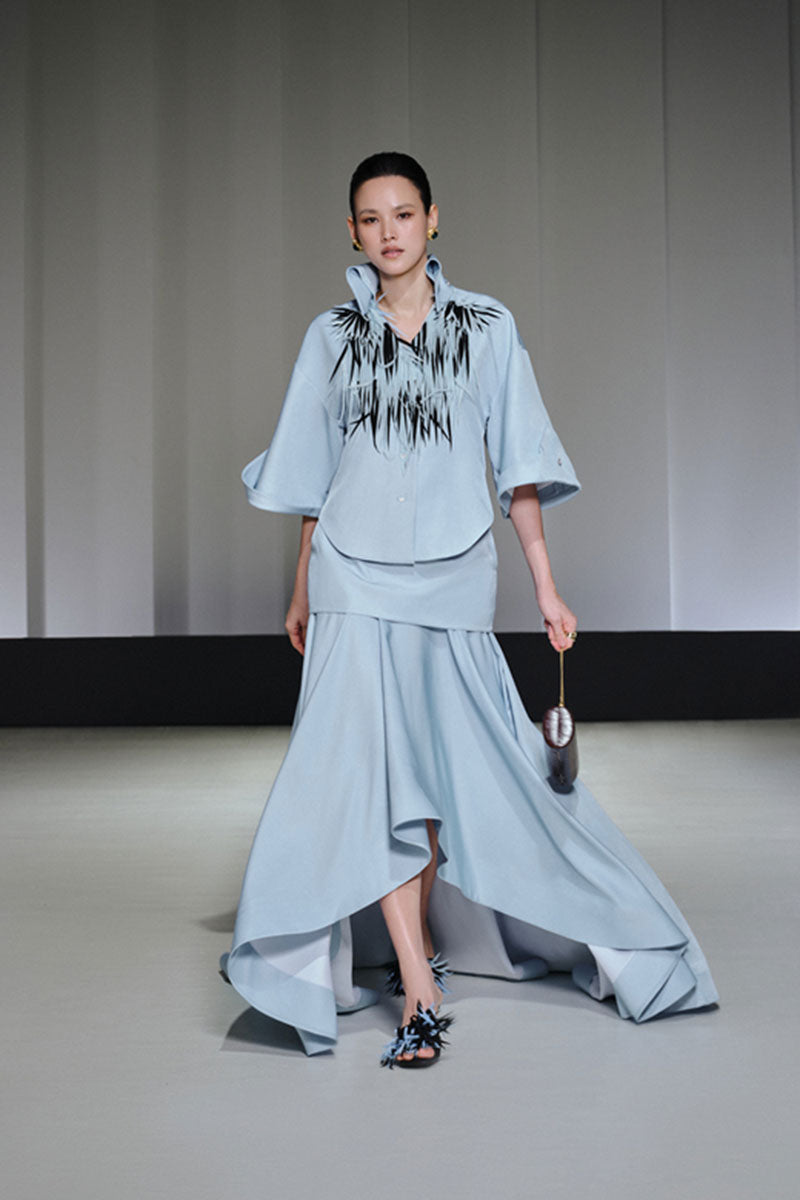 Jenny K Tran Colchester Top, stylish women's blouse with a relaxed fit and detailed neckline, shown on a hanger.