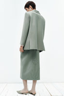 Green PODYH MEREZHYVO jacket with a sleek design, shown hanging on a hanger with a focus on the front view.