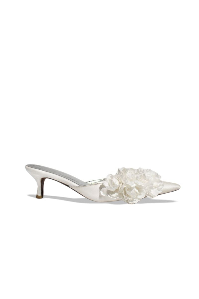 Christin Wu Camelia Cream Bloom Heels featuring elegant floral design and cream-colored straps on a stylish high-heel shoe.