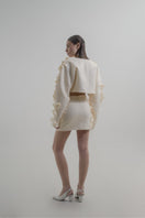 Blikvanger Milky Floral Bolero jacket with delicate floral pattern and lightweight fabric, displayed on a hanger.