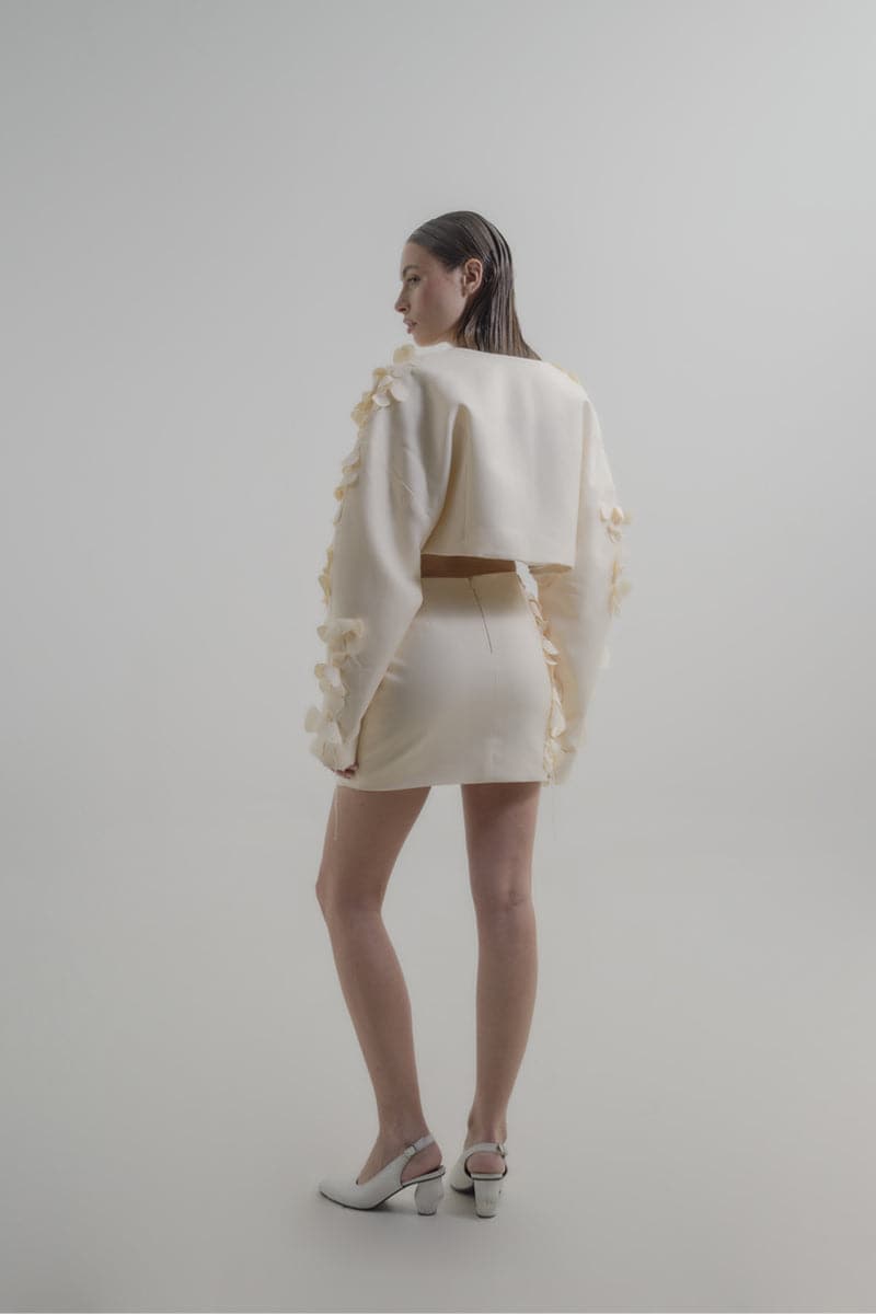 Blikvanger Milky Floral Bolero jacket with delicate floral pattern and lightweight fabric, displayed on a hanger.