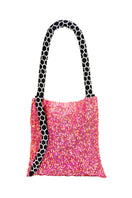 Small pink Serpent shoulder bag by SAC DE SOUL with black and white accents, featuring a textured serpent pattern and sleek design.