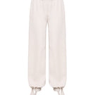 SÉLONE Selis balloon trousers in stone color with relaxed fit and elastic waistband, shown on a model.