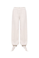 SÉLONE Selis balloon trousers in stone color with relaxed fit and elastic waistband, shown on a model.