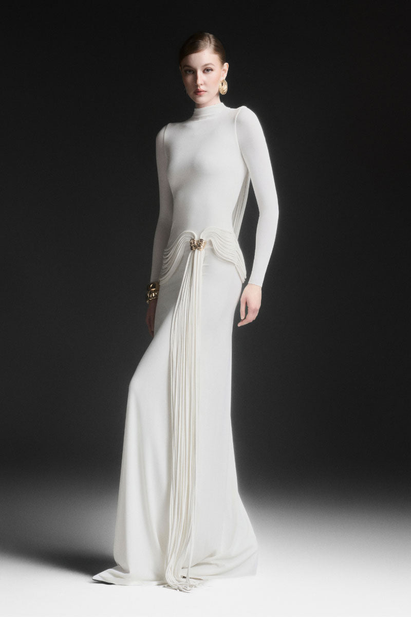 White Maison Des Copains corvina draped floor-length maxi dress displayed on a hanger with flowing fabric and elegant design.