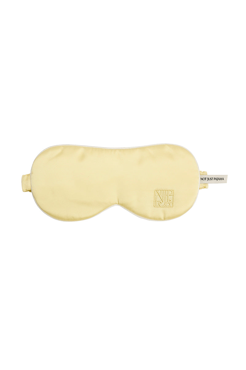 Soft butter yellow silk eye mask from Not Just Pajama, designed for comfortable loungewear and restful sleep.
