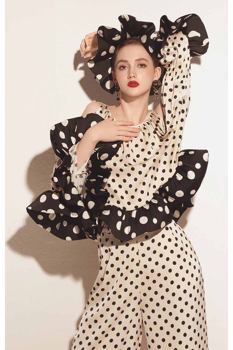 Cream Valenciani ruffle sleeve top with voluminous ruffle details, shown on a hanger with a soft background.